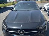 a black car parked in a parking lot next to other cars