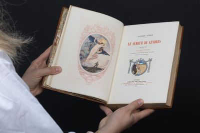 quelqu'un tient un livre sur lequel figure la photo d'une femme