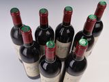 six bottles of wine are lined up in a row on a white surface