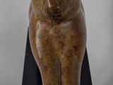 statue of a cat sitting on a black stand on a white background