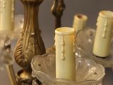 a chandelier that has a candle holder with candles on it