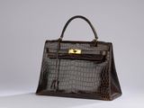 a brown crocodile skin handbag with gold hardware