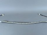 un bracelet en perles noires et blanches sur fond gris