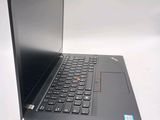 the laptop is open on a white surface with a blue sticker on the keyboard