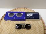 pair of sunglasses sitting on top of a bamboo tray next to a blue box