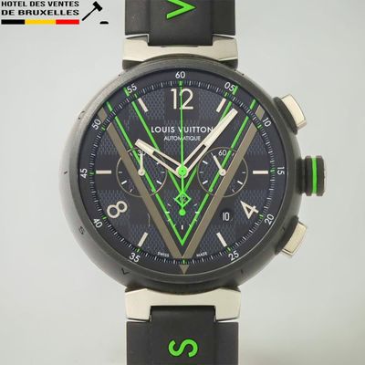 un gros plan d'une montre au cadran noir et aux aiguilles vertes