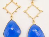 a pair of blue glass earrings on a white background