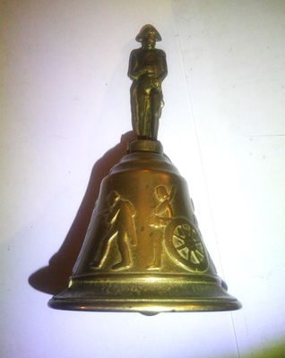 une cloche en or surmontée d'une statue