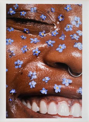 photograph of a close up of a person with blue flowers on their face