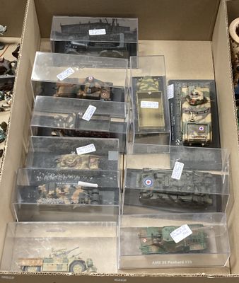 beaucoup de jouets militaires dans une boîte posée par terre