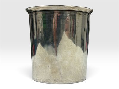 une poubelle en métal dans laquelle se trouve une substance blanche