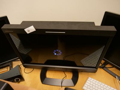 un bureau sur lequel se trouvent trois écrans et un clavier