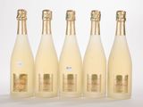 six bottles of champagne are lined up on a white surface