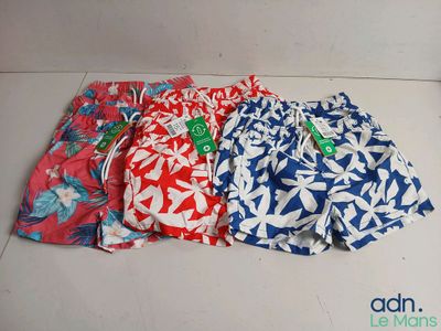trois maillots de bain pour homme sont alignés sur un sol carrelé