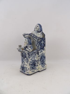 blue and white porcelain figurine of a woman holding a bird