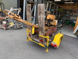 a small yellow fork truck with a large piece of wood in the back