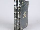 two books sitting on top of each other on a white surface