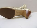 the bottom of a pair of women ' s gold shoes on a white surface