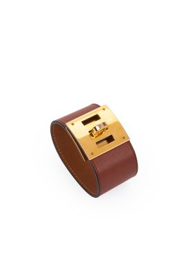 a close up of a brown leather bracelet on a white background