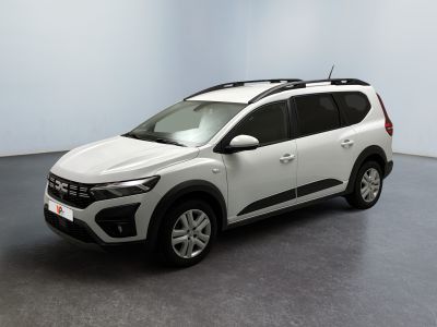 La voiture blanche est garée dans une pièce au sol gris.
