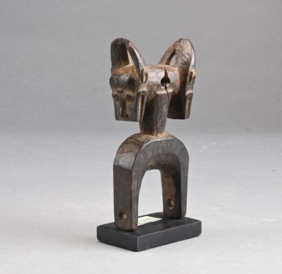 une sculpture en bois représentant une tête de cheval posée sur un socle noir