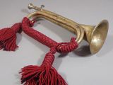 a brass trumpet with red tassels hanging from it
