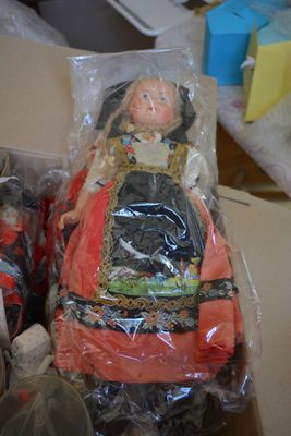 two dolls sitting in a box on a table