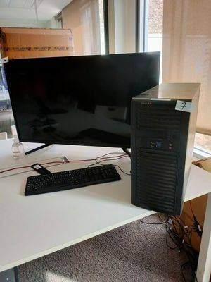 un ordinateur de bureau posé sur un bureau blanc