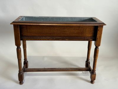 une vieille table en bois avec un plateau en verre, posée sur un plan de travail blanc