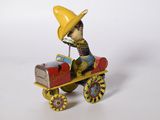 figurine représentant un homme coiffé d'un chapeau jaune au volant d'une petite voiture
