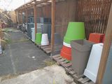 many trash cans lined up on pallets in a row