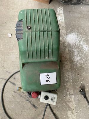 a green machine that is sitting on the ground