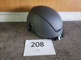 un casque posé par terre à côté d'un panneau indiquant « 208 »