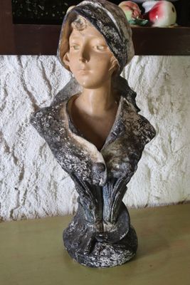 a bust of a woman wearing a scarf on a table