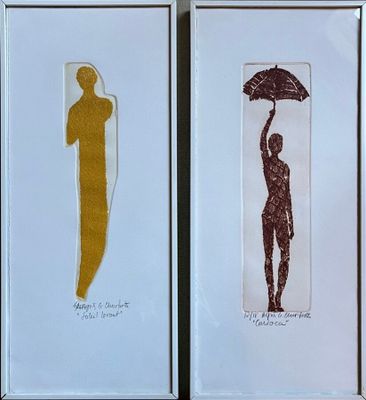 two framed pictures of a woman holding an umbrella and a man holding an umbrella