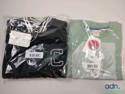 Deux t-shirts sont emballés dans des sacs en plastique sur une table