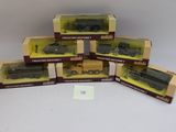 six boîtes contenant des trains miniatures, posées sur une surface blanche