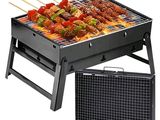 a black grill with skewers and vegetables on it