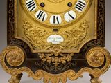 a gold clock with roman numerals on the face