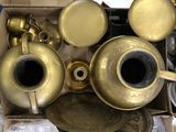 a lot of brass items in a box on the floor
