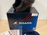 Le casque en forme de requin est posé sur une boîte posée sur la table.