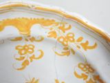 a yellow and white plate with a floral design on it
