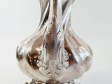 a silver vase that is sitting on a table