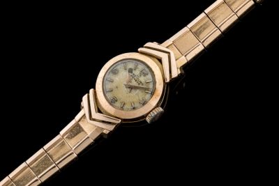a gold wrist watch with roman numerals on it