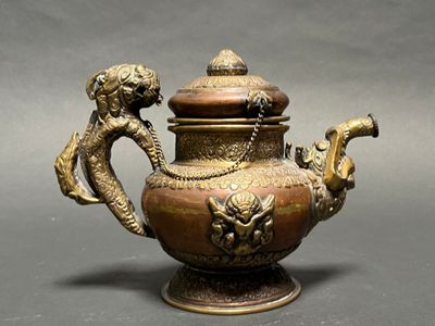 a bronze teapot with a dragon on the lid