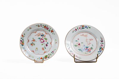 paire d'assiettes en porcelaine ornées de motifs floraux, présentées sur un présentoir