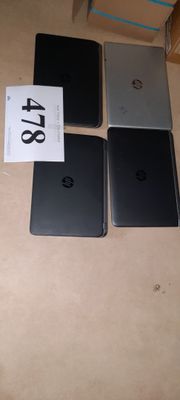 four laptops are sitting on a table with a price tag