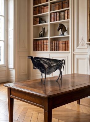 une statue représentant un oiseau posée sur une table dans un salon