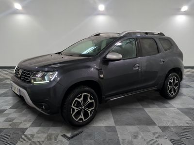 La Dacia grise est garée sur un sol à damier