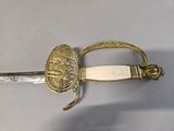 an image of a sword with a gold handle on a white surface